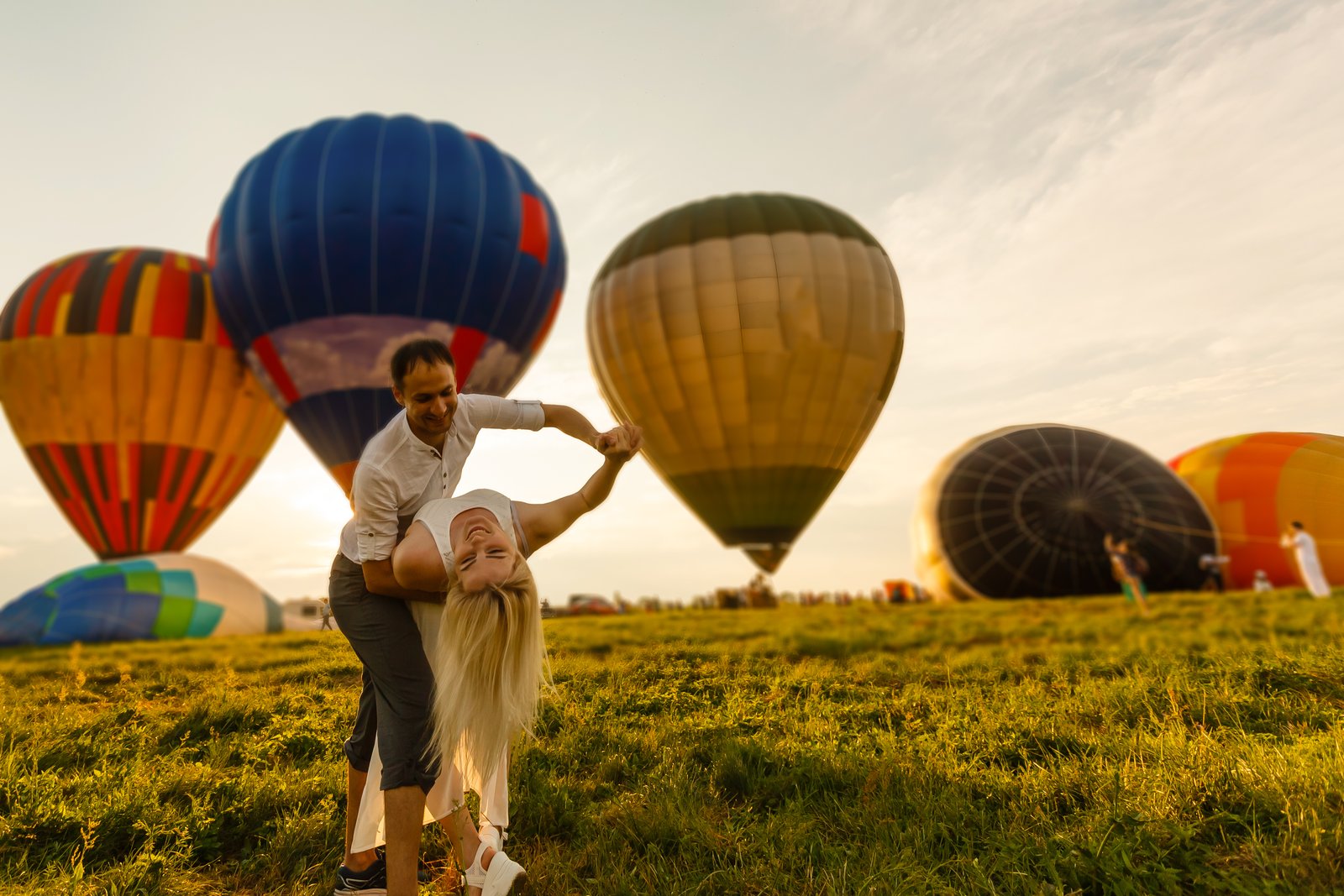 Couple in sunrise meadow before flight